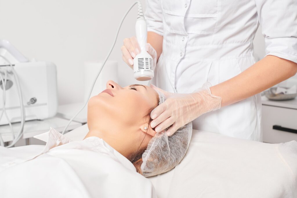 Beautician makes cryotherapy for rejuvenation woman face, anti aging procedure in salon
